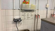 Rengöringsartiklar på hylla i tvättstuga